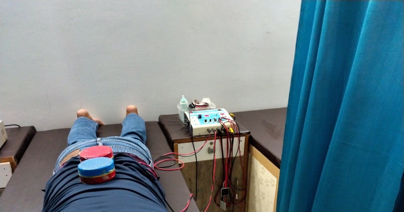 Patient lying on a bed during an electrotherapy session