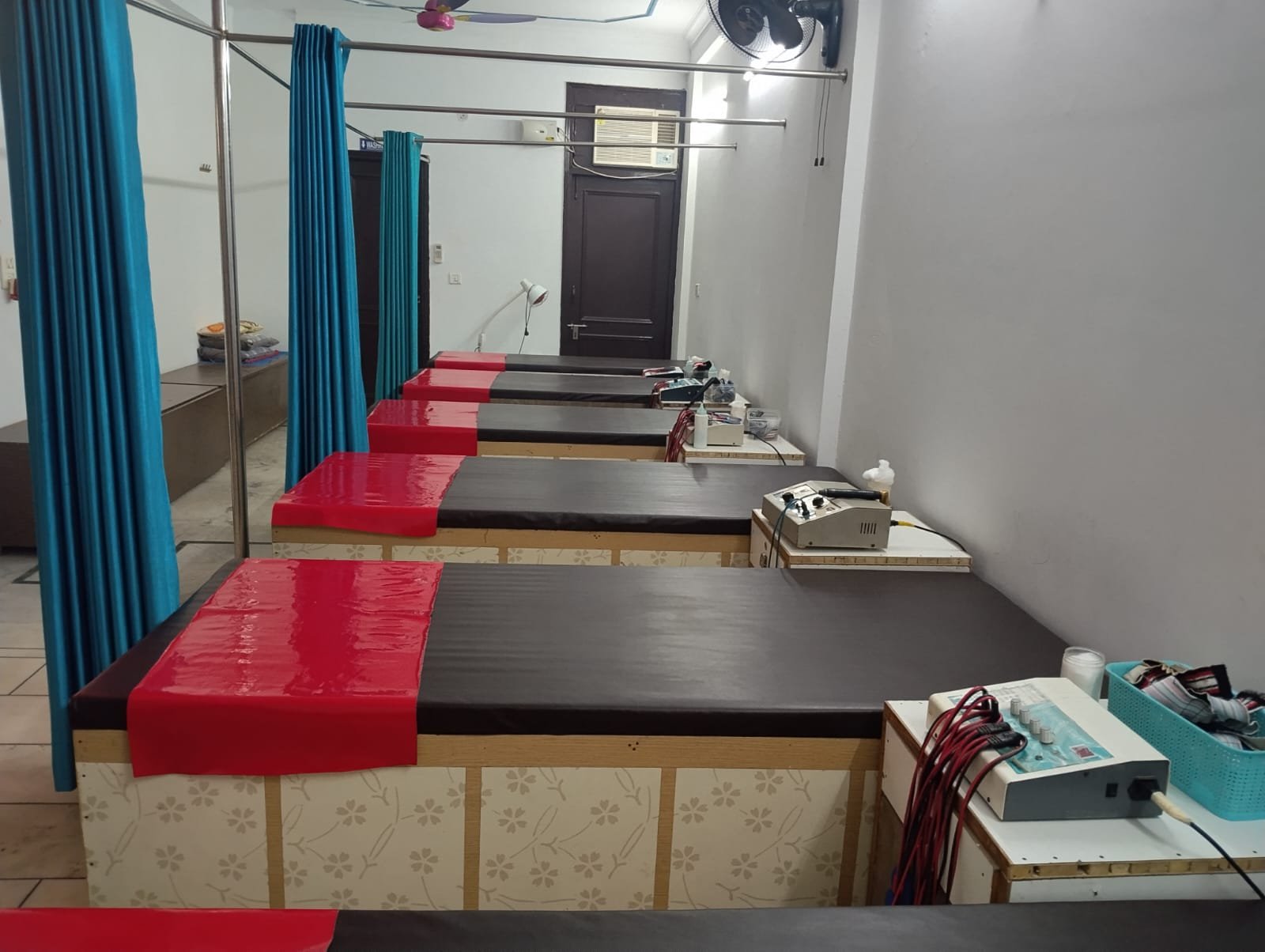 Treatment beds lined up with electrotherapy machines